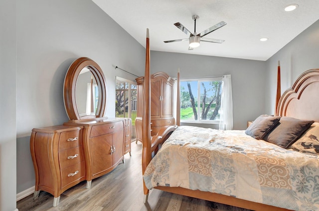 bedroom featuring ceiling fan, light hardwood / wood-style floors, and vaulted ceiling