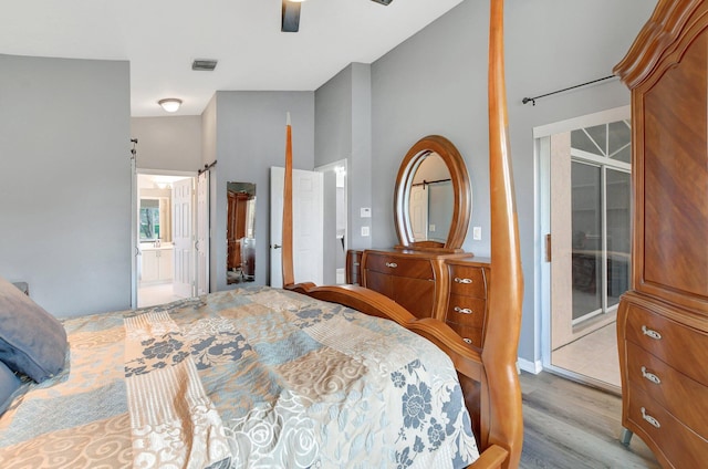 bedroom featuring ceiling fan, light hardwood / wood-style flooring, and ensuite bath