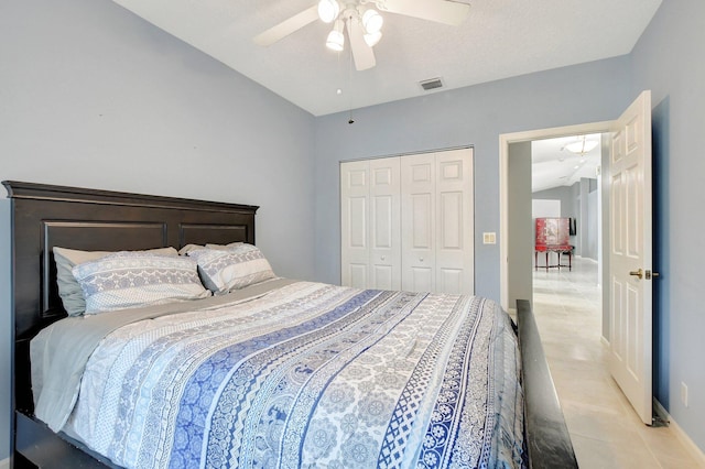 bedroom featuring ceiling fan, vaulted ceiling, light tile patterned floors, and a closet