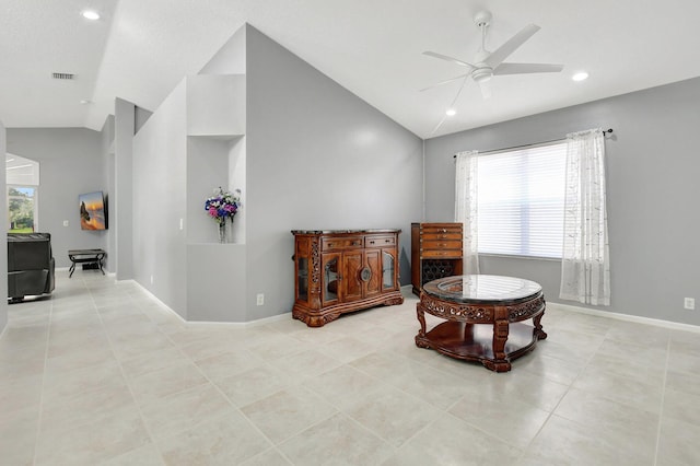 living area featuring ceiling fan, light tile patterned flooring, and vaulted ceiling