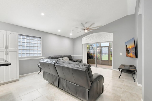 tiled living room featuring a textured ceiling, vaulted ceiling, and ceiling fan