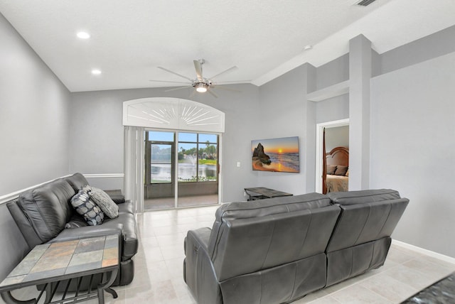 tiled living room featuring ceiling fan, a textured ceiling, and vaulted ceiling