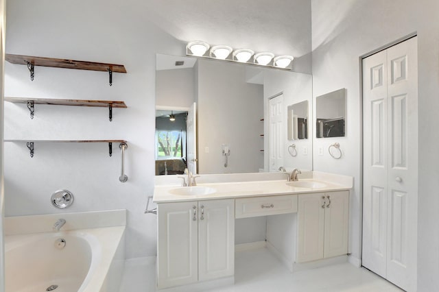 bathroom featuring ceiling fan, a tub, and vanity