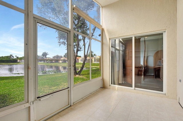 unfurnished sunroom featuring a water view