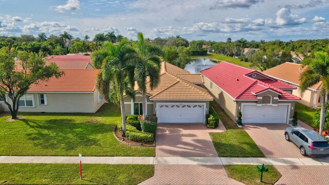 mediterranean / spanish-style home with a garage and a front lawn