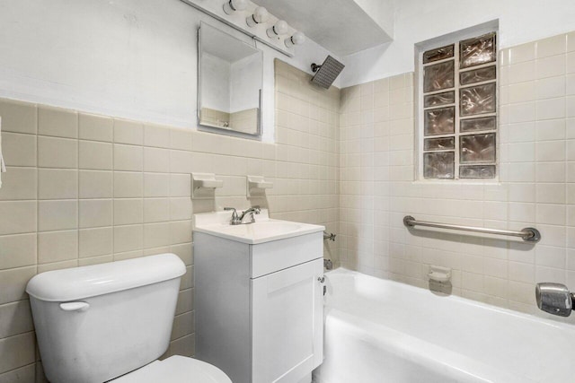 bathroom featuring a washtub, vanity, tile walls, and toilet