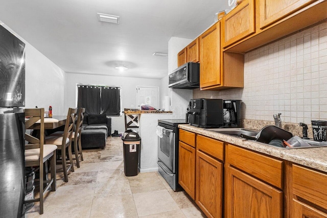 kitchen with decorative backsplash, stainless steel electric range oven, sink, and light tile patterned floors