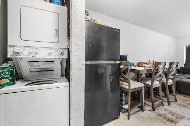 clothes washing area featuring stacked washer and clothes dryer