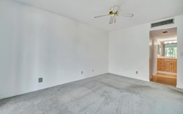 carpeted spare room featuring ceiling fan