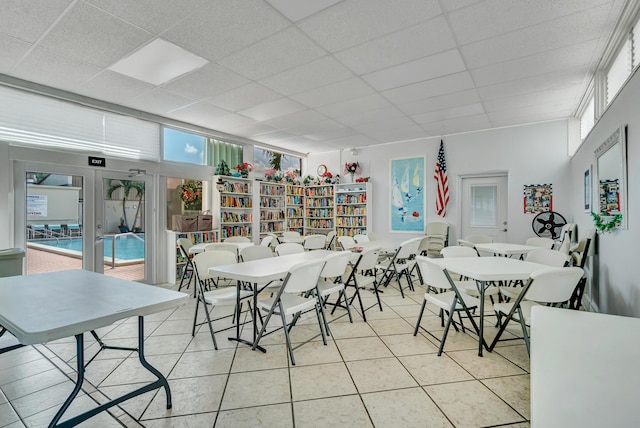 dining room featuring a drop ceiling and light tile patterned flooring