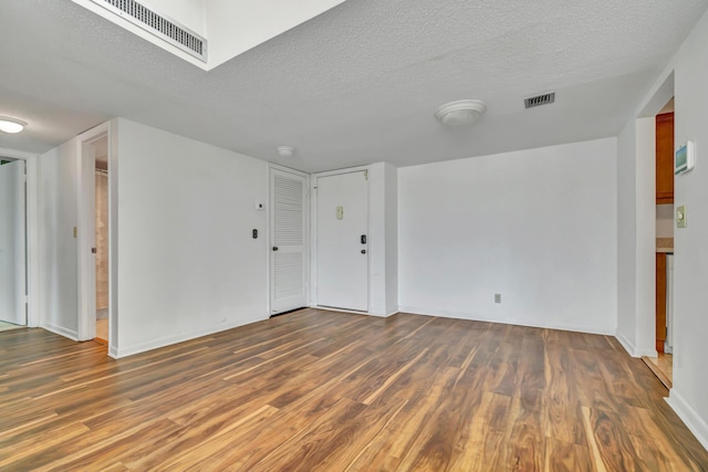 unfurnished room featuring a textured ceiling and dark wood-type flooring