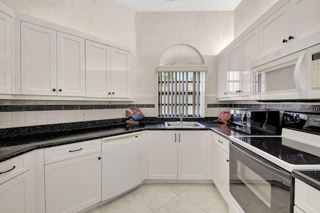 kitchen with tasteful backsplash, white appliances, white cabinets, and a sink