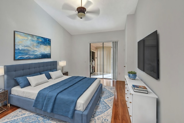 bedroom with ceiling fan, a closet, wood finished floors, and lofted ceiling