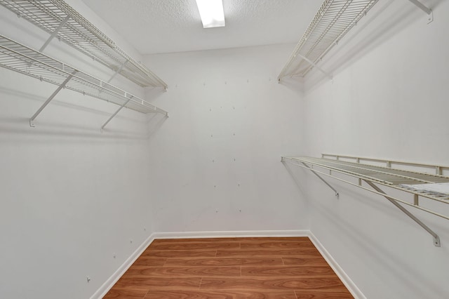 walk in closet with wood finished floors