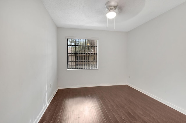 unfurnished room featuring dark wood-style floors, a ceiling fan, baseboards, and a textured ceiling