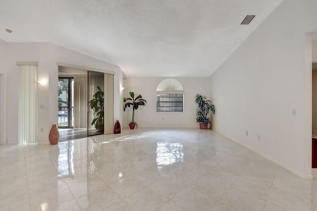 unfurnished room featuring a textured ceiling, visible vents, and baseboards