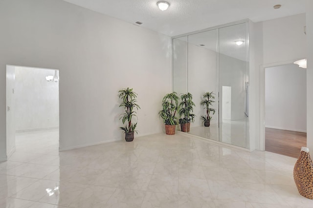 interior space featuring baseboards, visible vents, and a textured ceiling