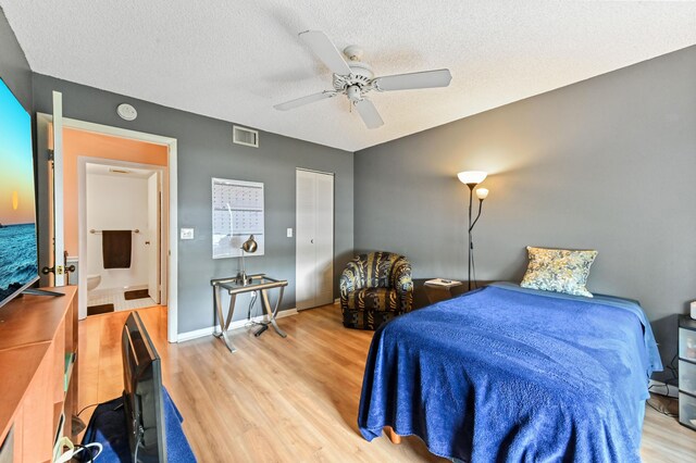 bedroom featuring light wood-type flooring, a textured ceiling, and ceiling fan