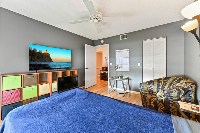 bedroom featuring ceiling fan, a closet, and wood-type flooring