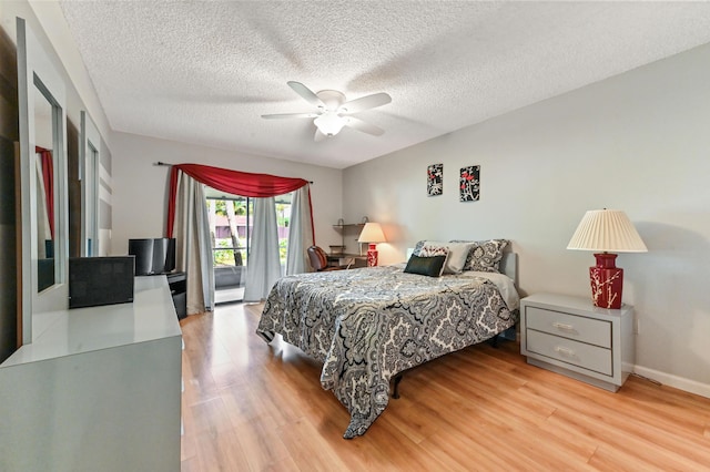 bedroom featuring light wood-type flooring, ceiling fan, access to outside, and a textured ceiling