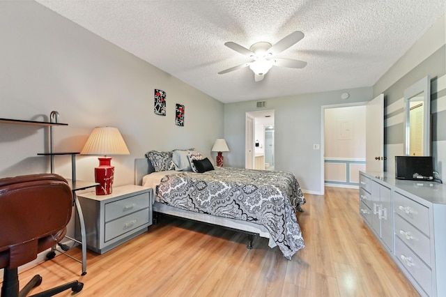 bedroom with light hardwood / wood-style flooring, ceiling fan, and a textured ceiling