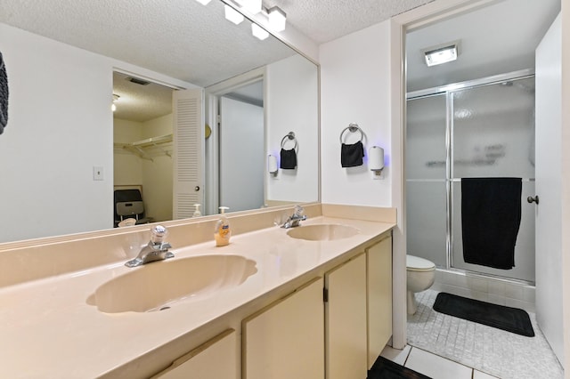 bathroom featuring tile patterned floors, a shower with shower door, and a textured ceiling