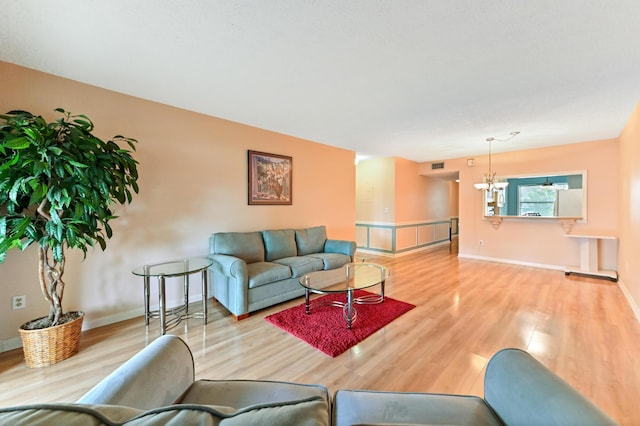 living room with light wood-type flooring and a chandelier