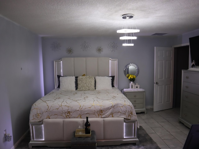 bedroom featuring tile patterned flooring and a textured ceiling