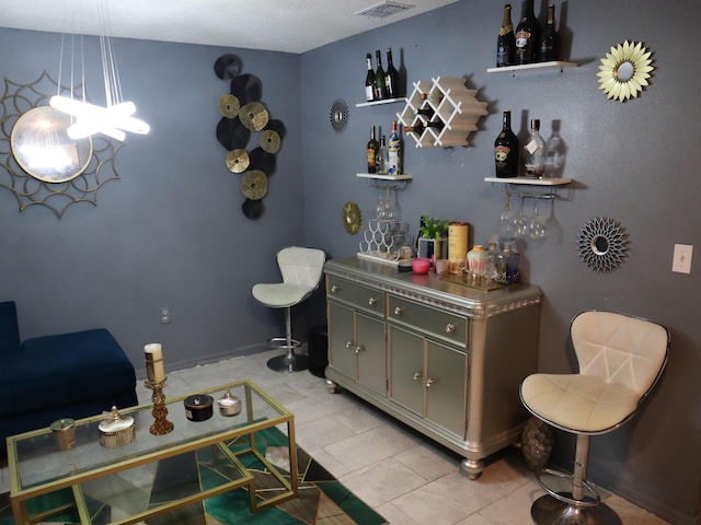 interior space featuring hanging light fixtures, stainless steel counters, and light tile patterned flooring