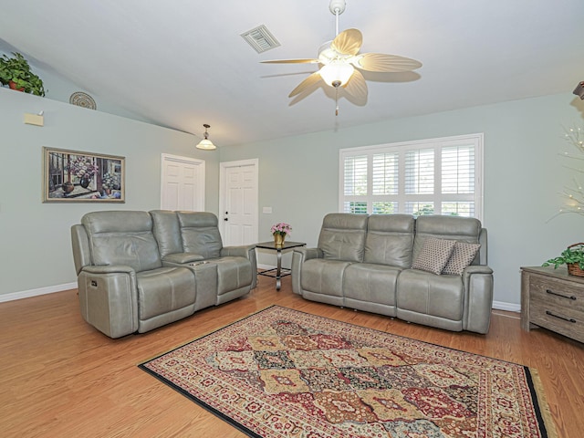 living room with ceiling fan, lofted ceiling, and hardwood / wood-style flooring