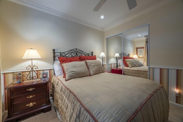 carpeted bedroom featuring a closet, ornamental molding, and ceiling fan