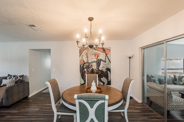 dining area featuring dark hardwood / wood-style flooring and an inviting chandelier