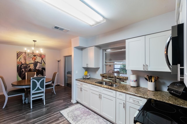 kitchen featuring white cabinetry, black appliances, and decorative light fixtures