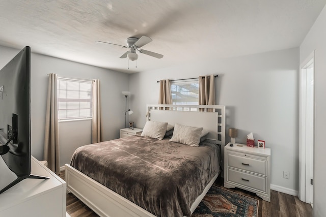 bedroom with ceiling fan, dark hardwood / wood-style flooring, and multiple windows