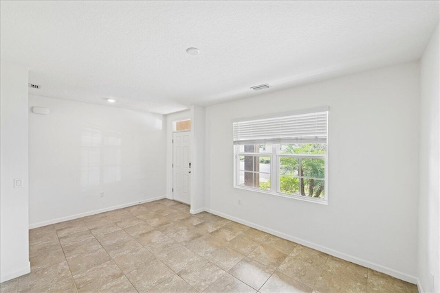 unfurnished room with a textured ceiling