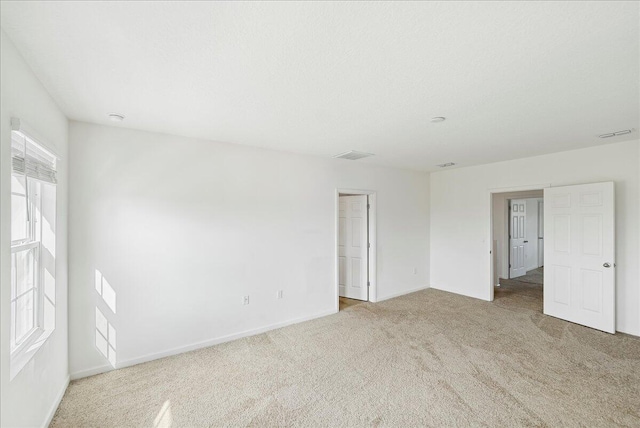 carpeted spare room featuring plenty of natural light