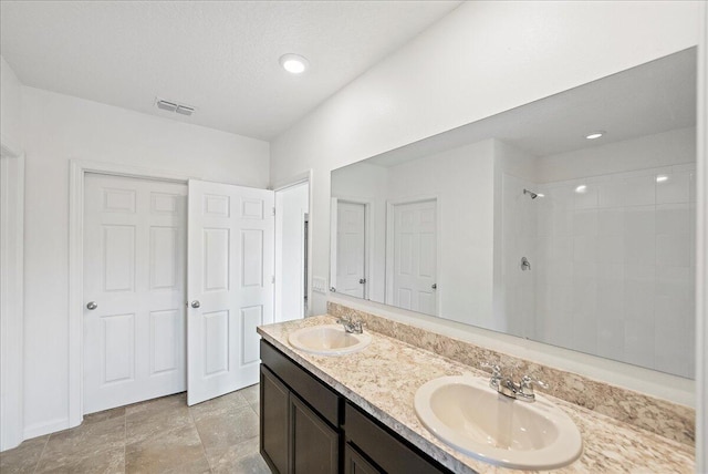 bathroom featuring vanity, a textured ceiling, and walk in shower