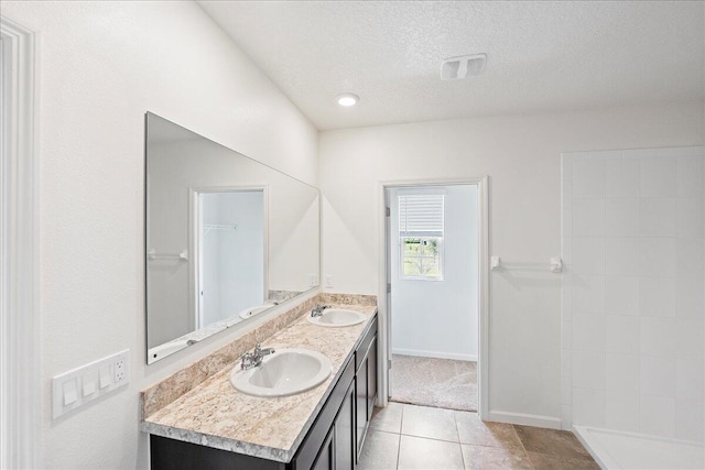 bathroom with vanity, a textured ceiling, and tile patterned flooring