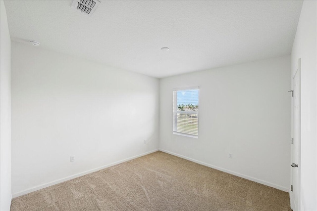 spare room with carpet floors and a textured ceiling