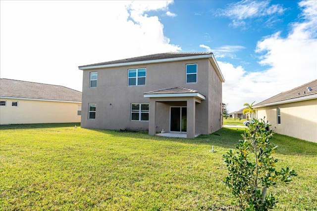 rear view of property featuring a lawn