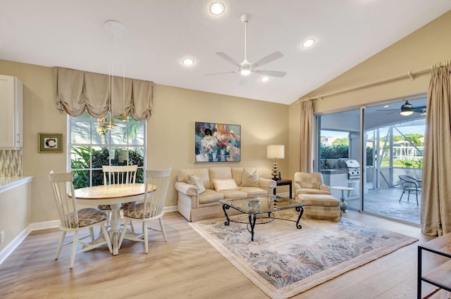 living room featuring vaulted ceiling, ceiling fan, and light hardwood / wood-style flooring