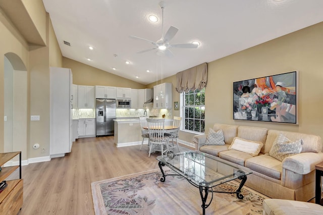 living room with ceiling fan, lofted ceiling, and light wood-type flooring