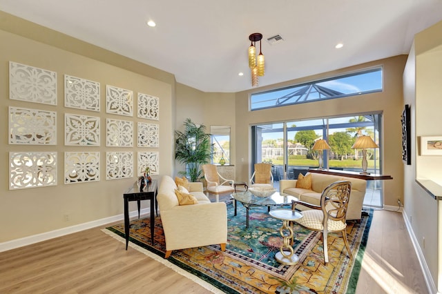 living room with a high ceiling and hardwood / wood-style flooring