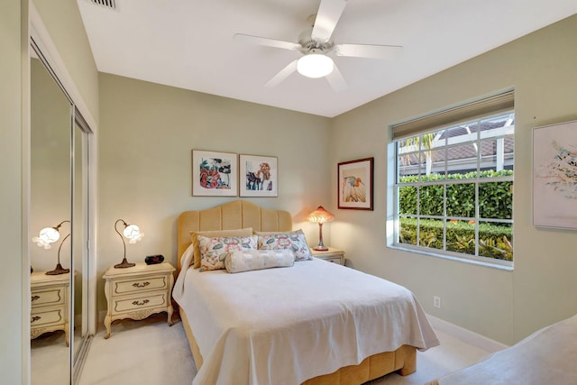 carpeted bedroom with ceiling fan and a closet