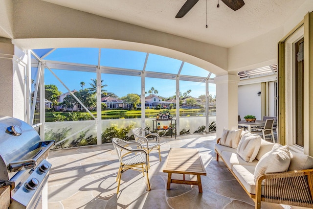 sunroom / solarium with a water view and ceiling fan