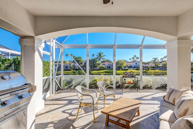 view of patio / terrace featuring area for grilling, exterior kitchen, and a water view