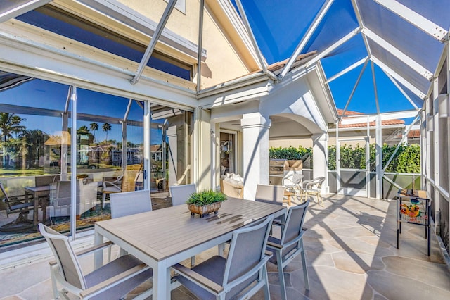 sunroom / solarium featuring vaulted ceiling and decorative columns