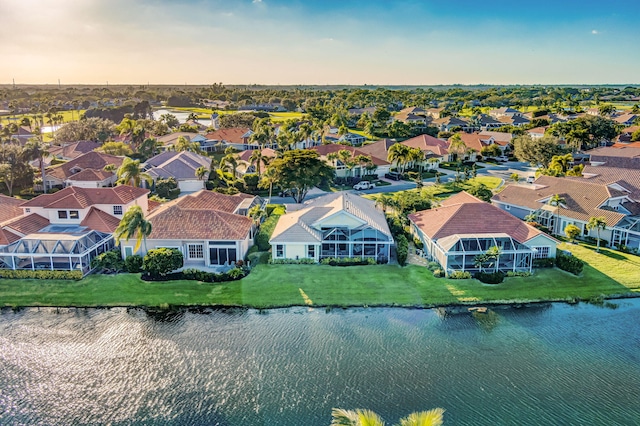 aerial view at dusk featuring a water view