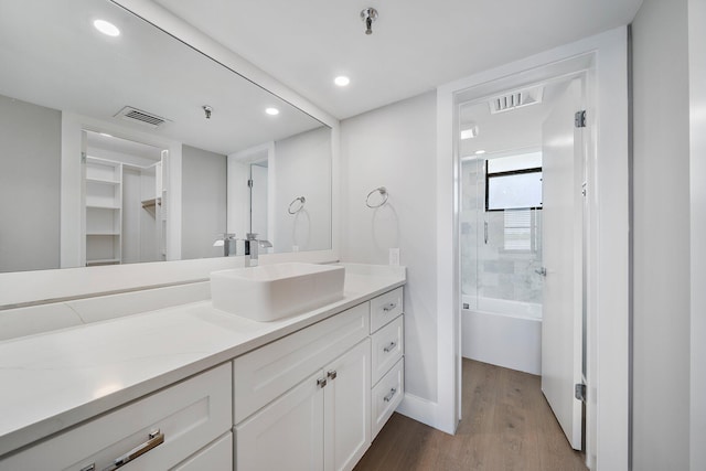 bathroom featuring vanity, wood-type flooring, and tiled shower / bath combo