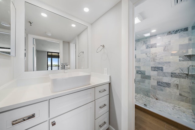 bathroom featuring wood-type flooring, vanity, and a shower with shower door